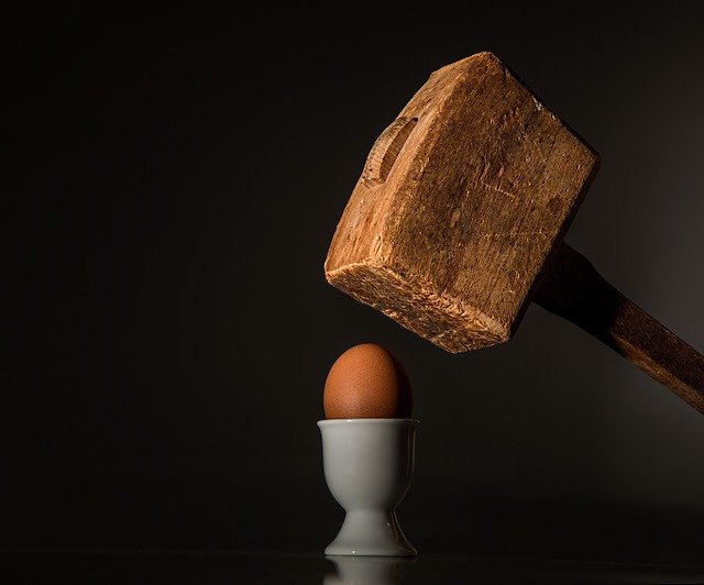 Big hammer smashing an egg
